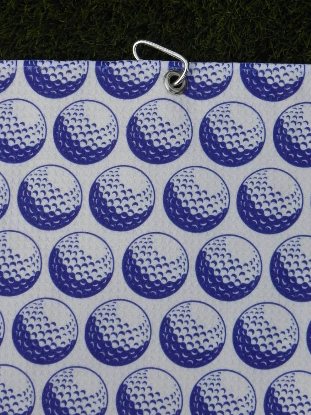 White and Blue towel laid flat, highlighting metal grommet hole and stitching—ready for clip attachment to any golf bag.