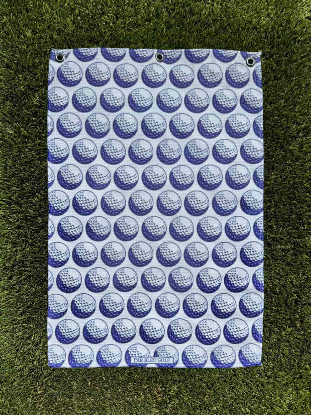 Blue towel laid fully flat on grass, clearly showing its pattern and proportions—ideal for shoppers seeking full design view.