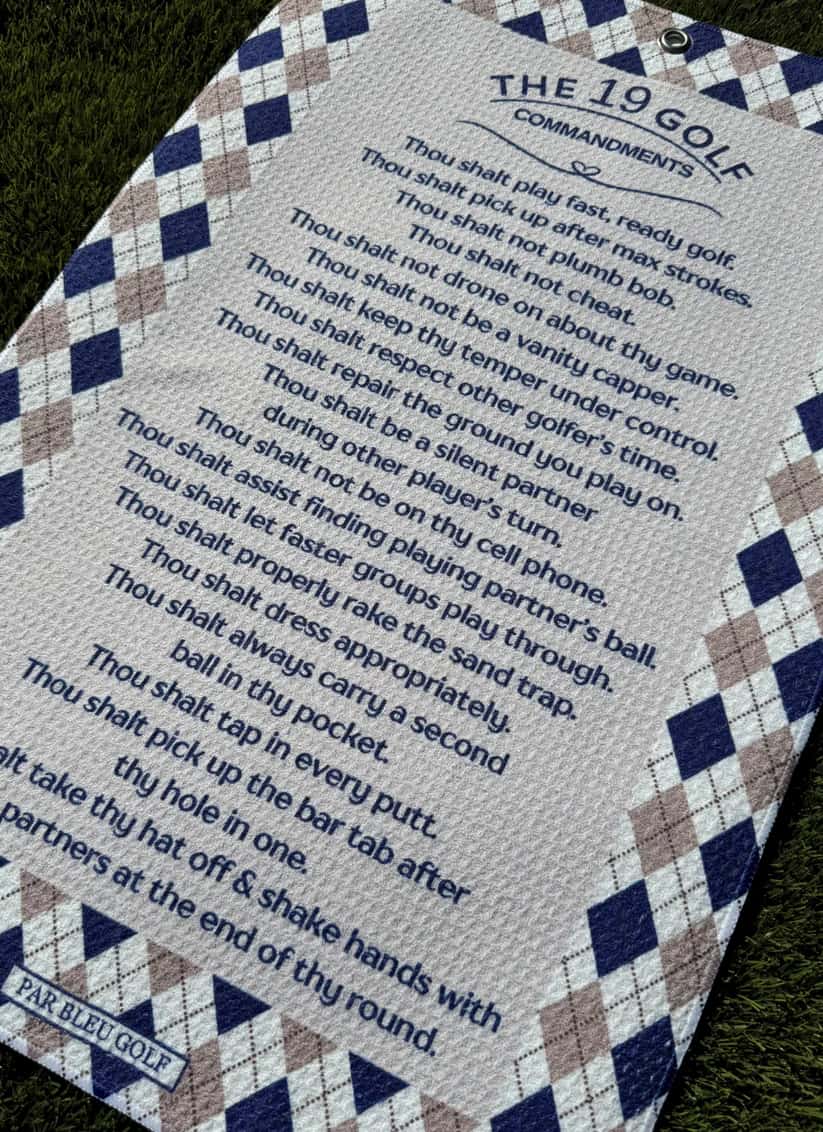 Angled close-up of golf towel showing The 19 Golf Commandments and diamond argyle border