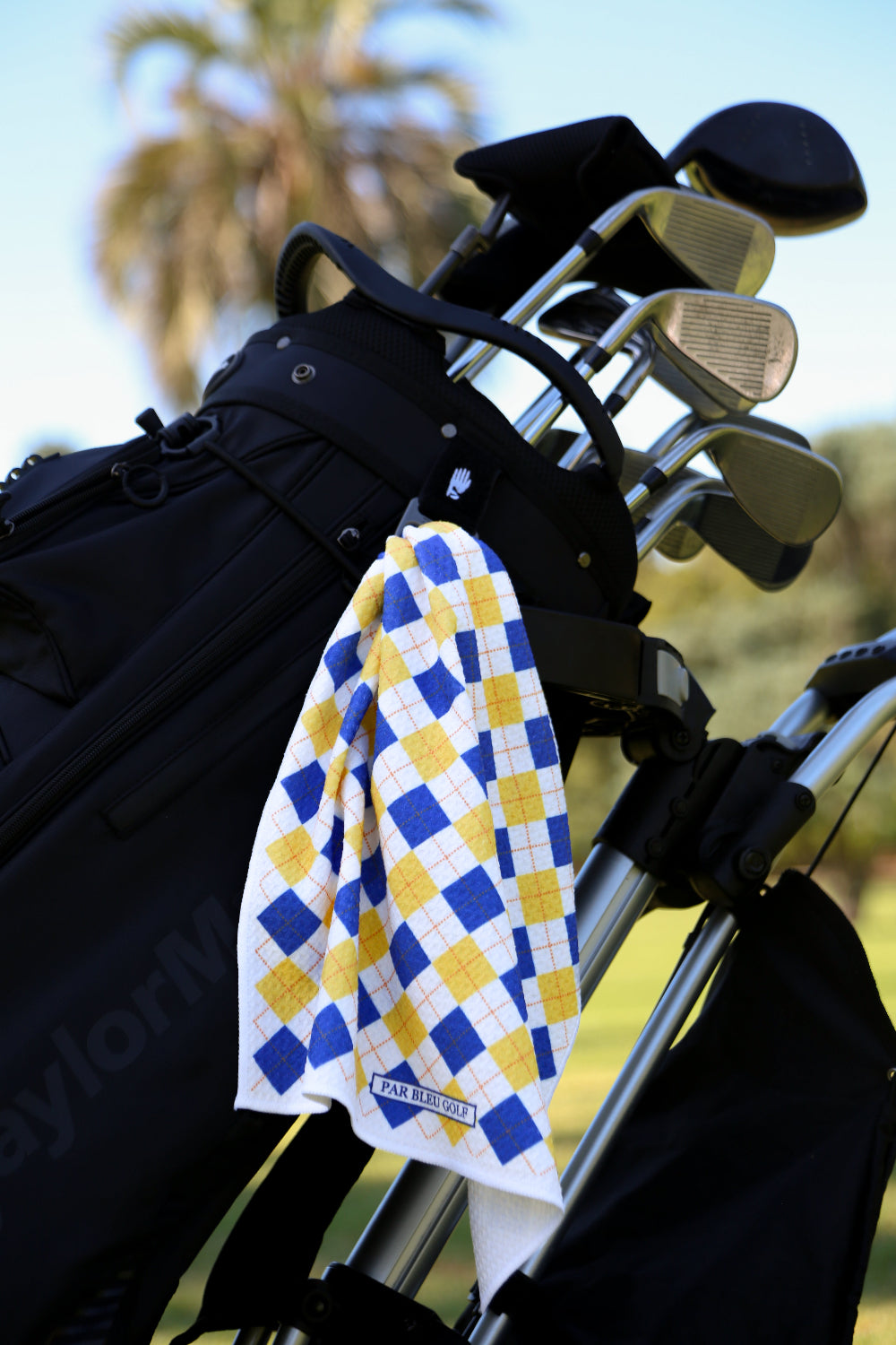 Blue and yellow plaid golf towel clipped to black golf bag, ideal stylish golf gift