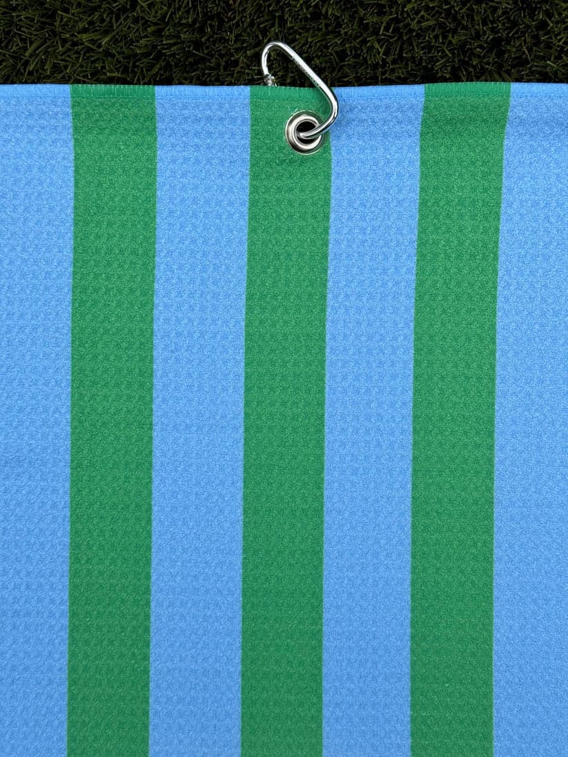 Bright green and blue striped golf towel hanging vertically from a metal carabiner
