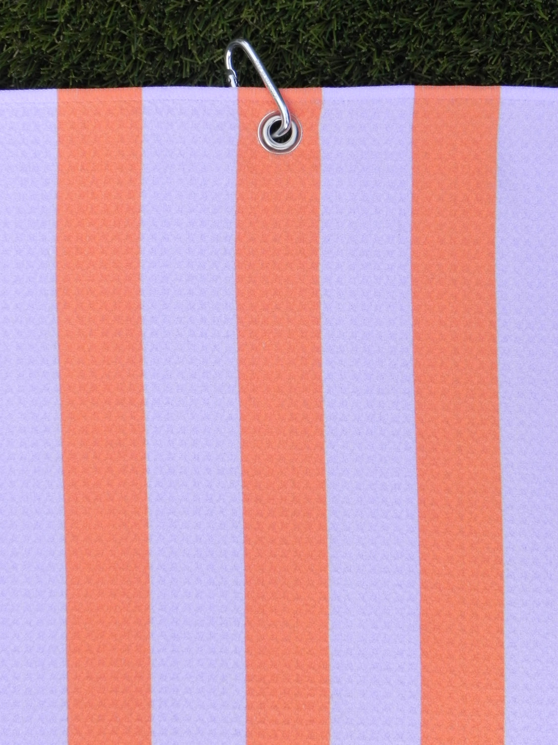 Striped pink and orange microfiber golf towel hanging by durable silver carabiner