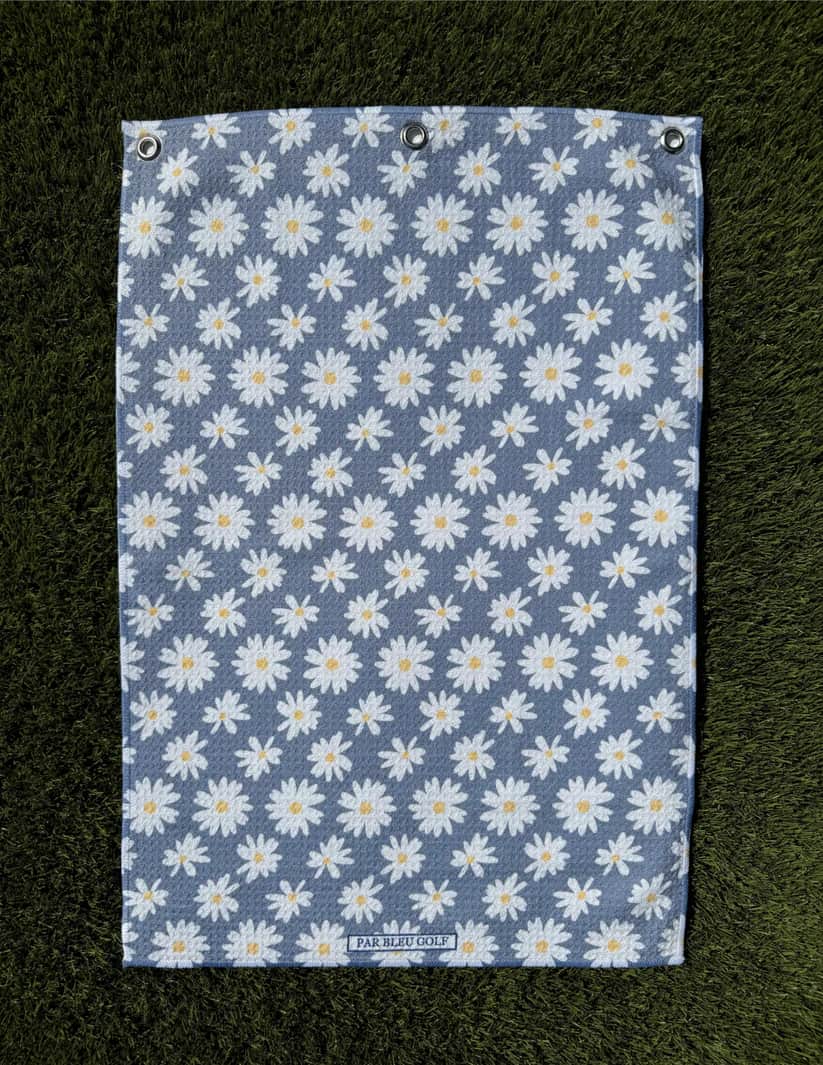 The Grey Daisy microfiber towel laid flat on grass showing clean floral pattern