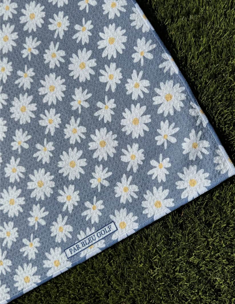 Close-up of The Grey Daisy microfiber golf towel with Par Bleu logo and floral daisy design