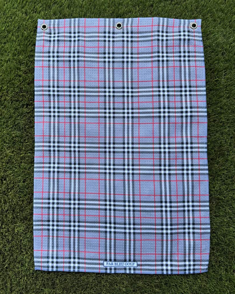 The Grey Plaid golf towel laid flat on grass, showcasing clean plaid pattern and soft microfiber material
