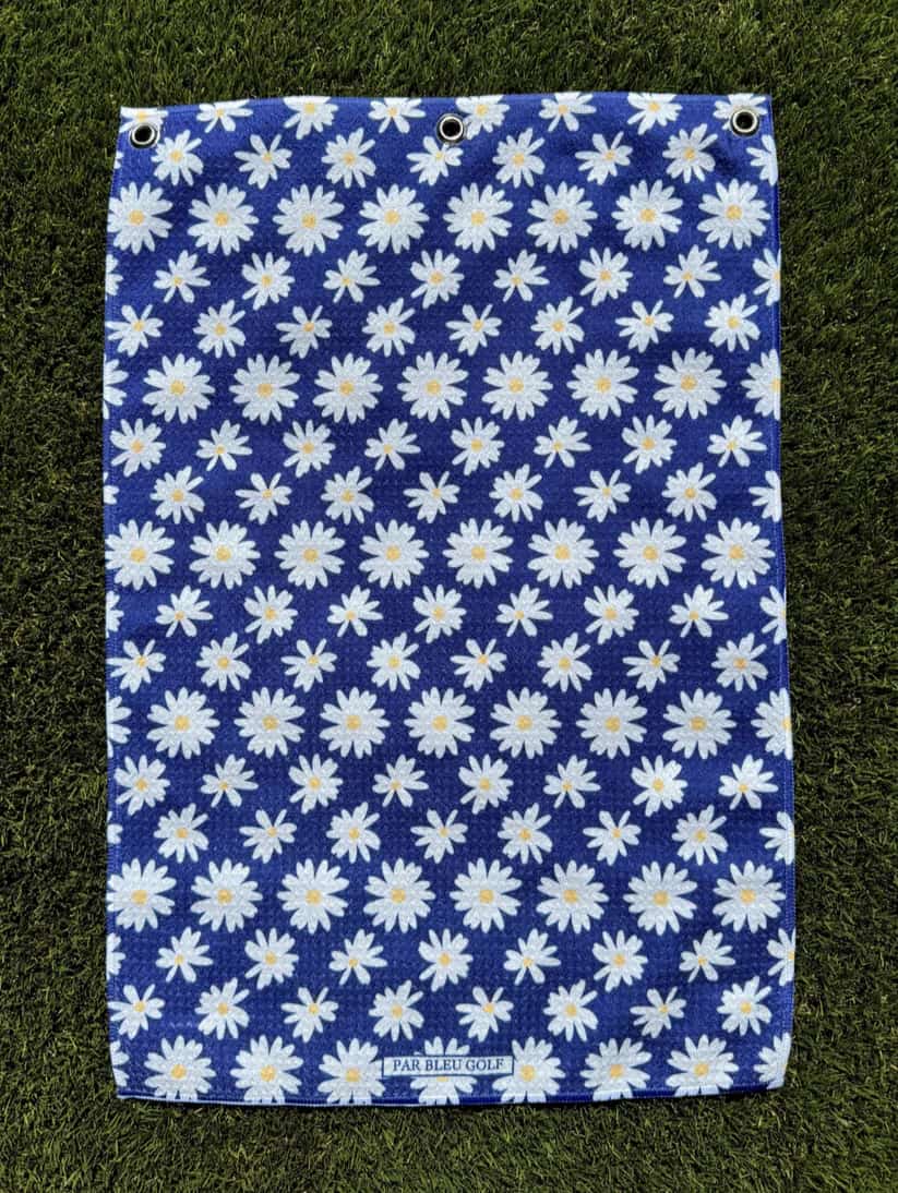 The Navy Daisy golf towel laid flat showing feminine floral design on soft navy microfiber