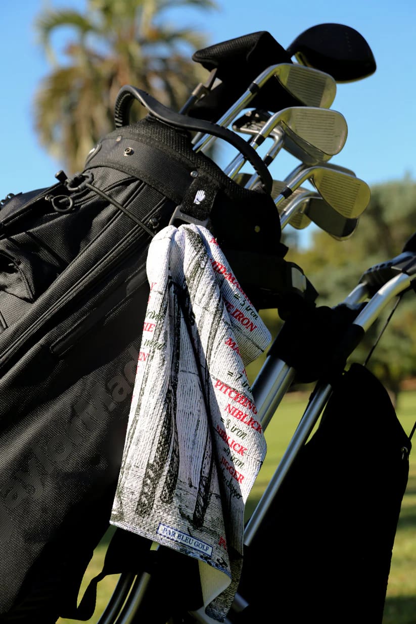Golf towel featuring vintage club artwork clipped to black golf bag, a bold towel choice for any golfer