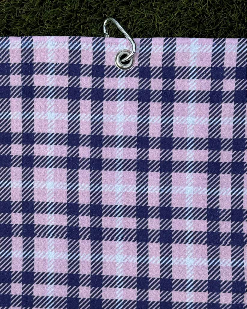 Pink and navy plaid golf towel hanging vertically with metal carabiner clip, soft microfiber material