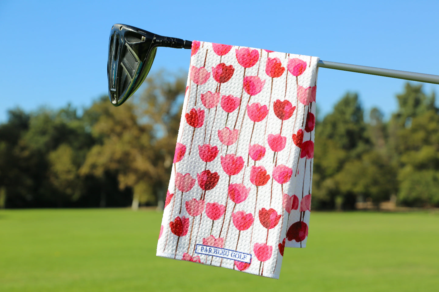 Floral golf towel with red tulips hanging on club, designed for women golfers and spring golf style