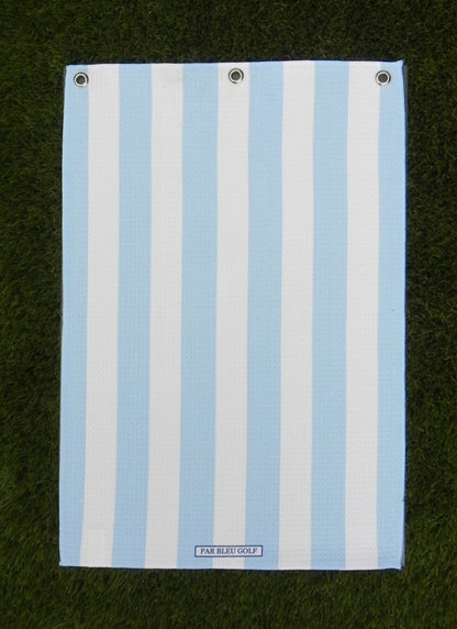 Cabana Stripe golf towel in blue and white laid flat on grass, showing clean stripe pattern