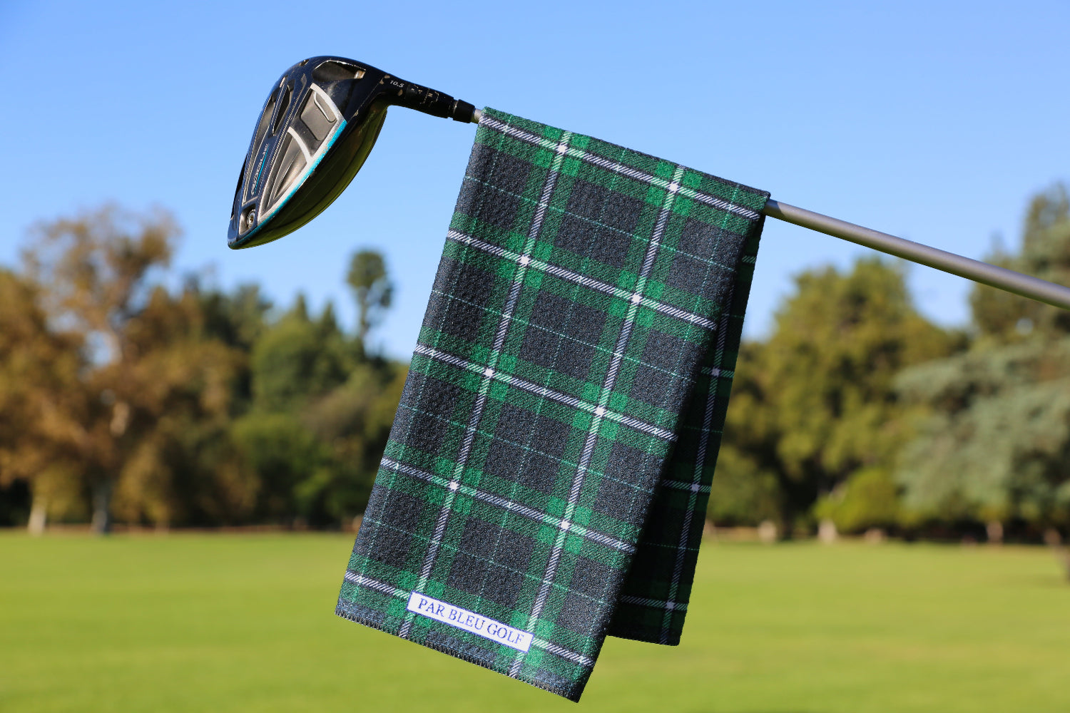 Emerald green and navy plaid golf towel hanging on a club, classic microfiber golf accessory