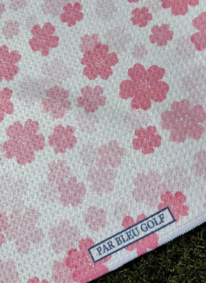 Close-up of Par Bleu’s Pretty in Pink Floral microfiber towel with delicate cherry blossom pattern and logo tag
