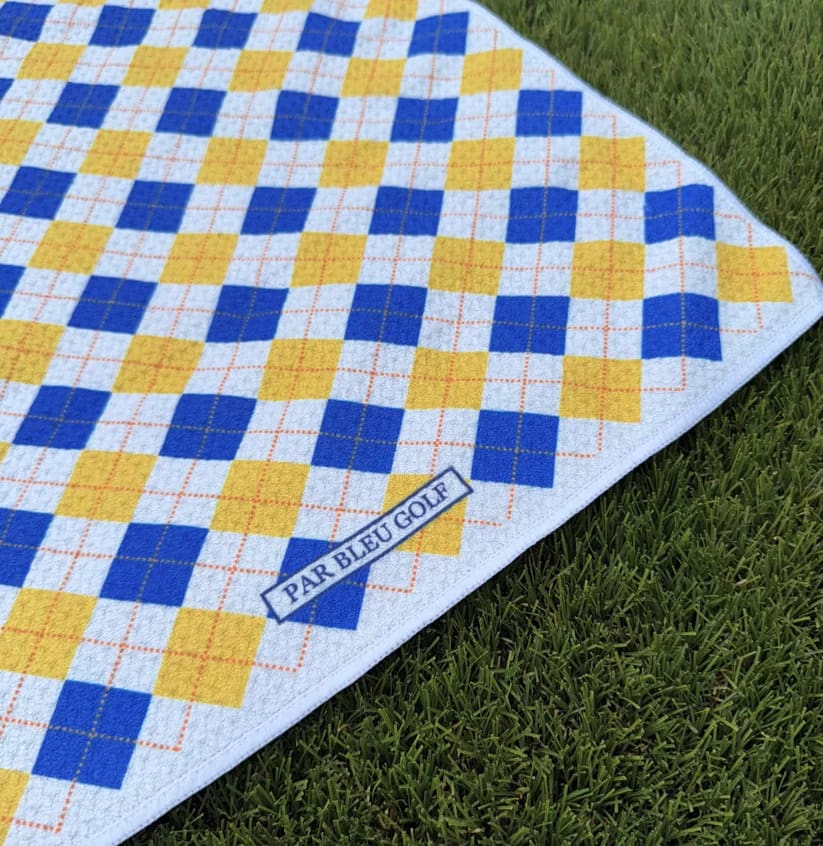 Close-up of The Argyle Chipper: Blue & Gold towel with Par Bleu logo and diamond plaid pattern