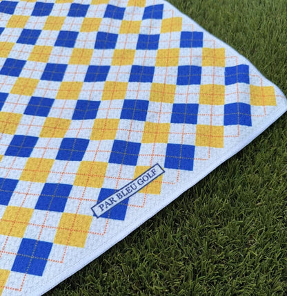 Close-up of The Argyle Chipper: Blue & Gold towel with Par Bleu logo and diamond plaid pattern