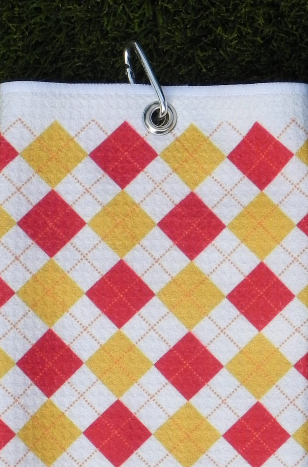 Red and gold plaid microfiber golf towel hanging from silver carabiner clip