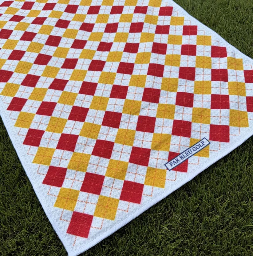 Close-up of The Argyle Chipper: Cardinal & Gold golf towel with Par Bleu logo and bold check pattern