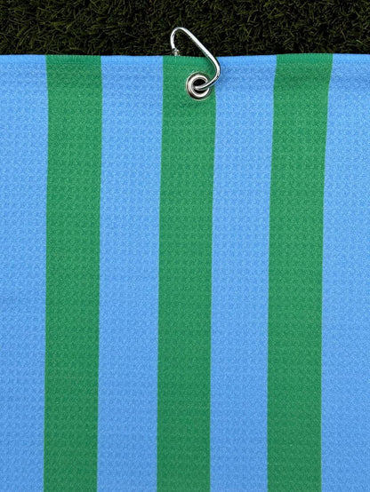 Bright green and blue striped golf towel hanging vertically from a metal carabiner