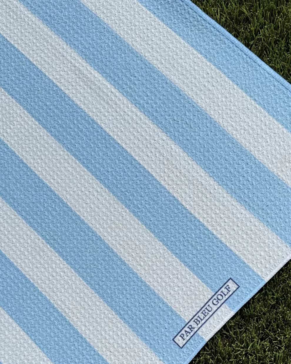 Close-up of blue and white striped Cabana golf towel with Par Bleu logo tag