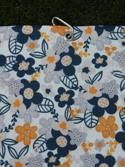 Floral golf towel for women in shades of grey and yellow, hanging vertically with secure metal carabiner