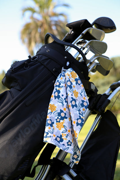 Feminine grey and yellow floral towel clipped to golf bag, designed for women golfers seeking style and function