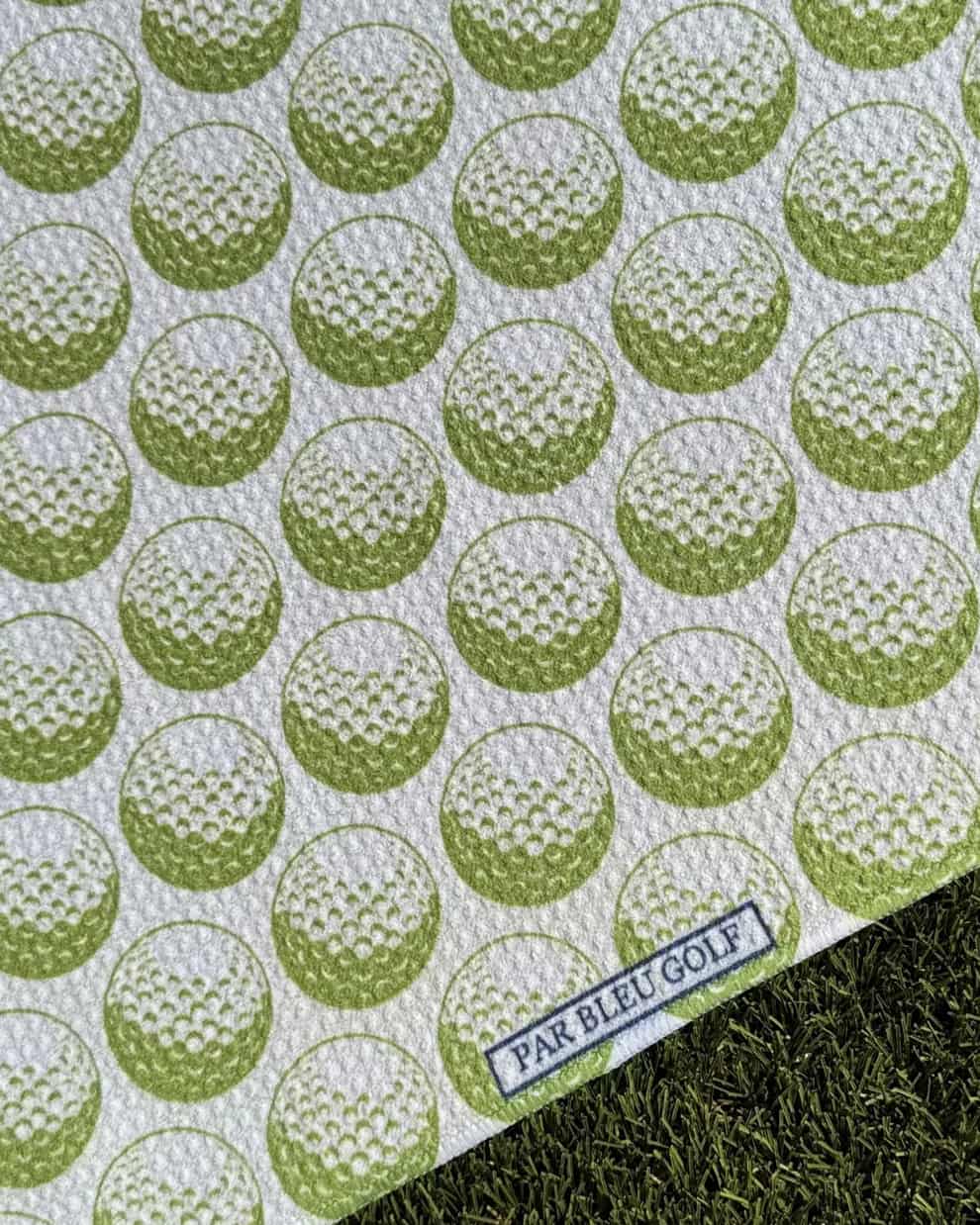 Close-up of green golf ball pattern towel with Par Bleu logo tag