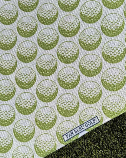 Close-up of green golf ball pattern towel with Par Bleu logo tag