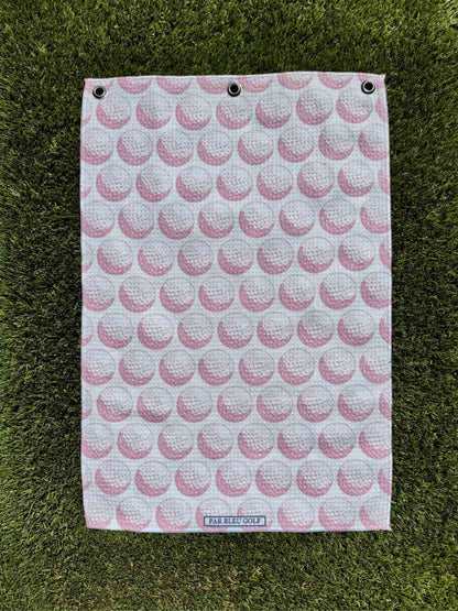 The Golf Ball: Pink towel laid flat on grass, showing full pattern design