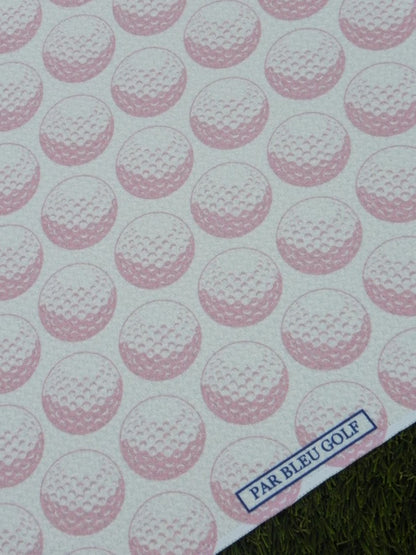 Close-up of pink golf ball pattern with Par Bleu logo tag on towel