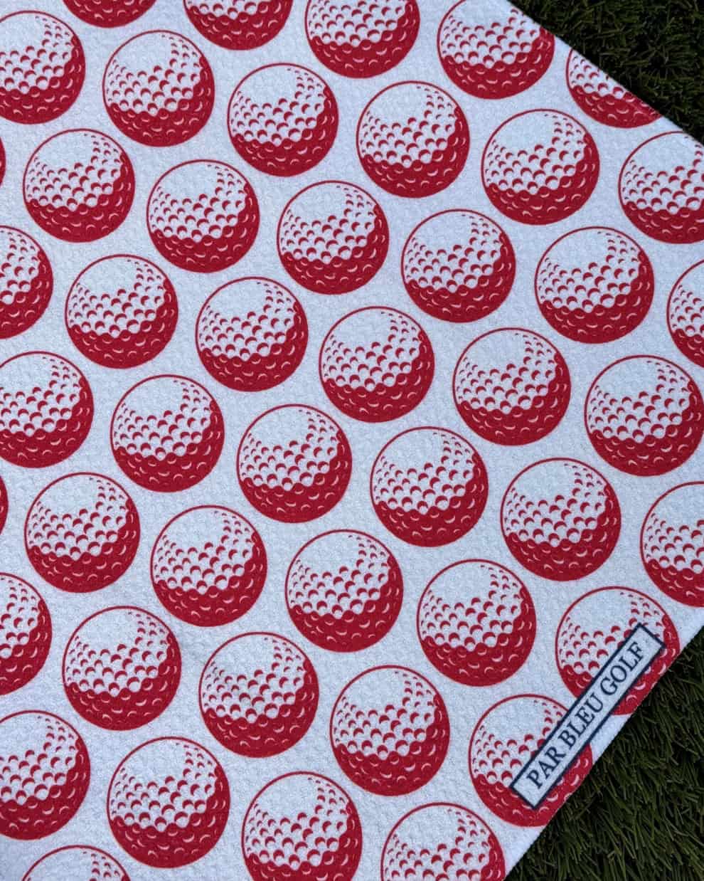 Close-up of red golf ball pattern on microfiber golf towel