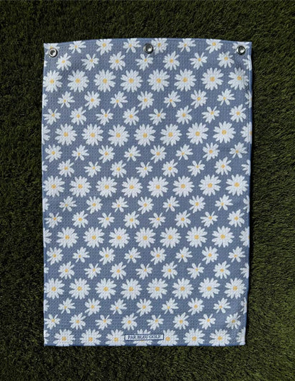 The Grey Daisy microfiber towel laid flat on grass showing clean floral pattern