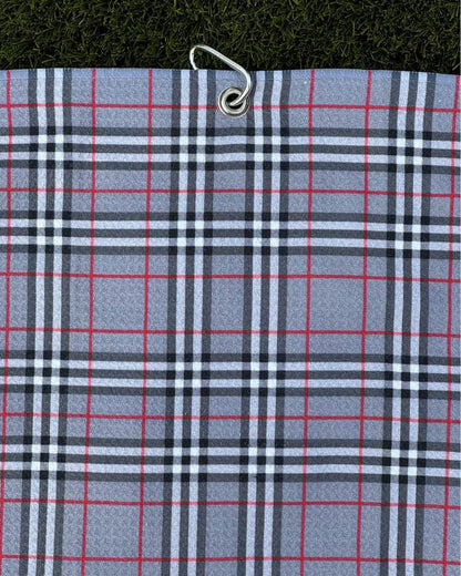 Grey plaid golf towel hanging vertically with metal carabiner, featuring red and black stripe