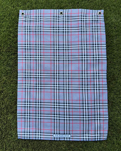 The Grey Plaid golf towel laid flat on grass, showcasing clean plaid pattern and soft microfiber material