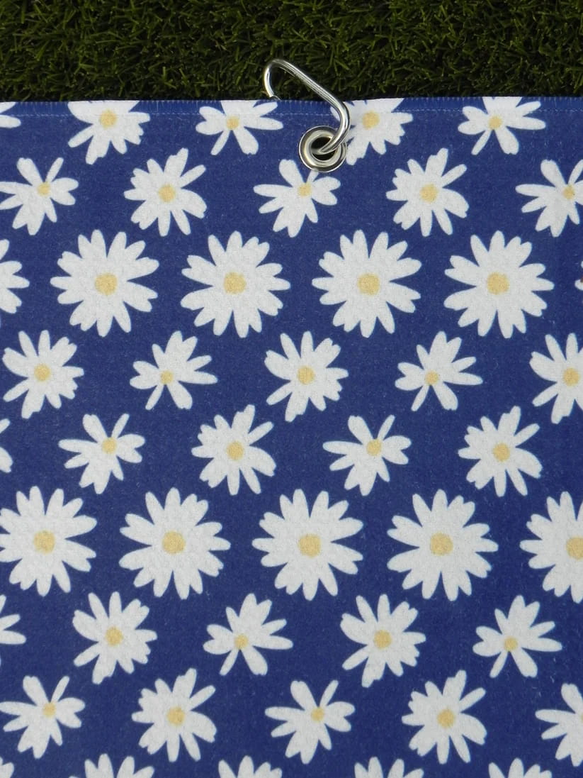 Floral microfiber golf towel for women in navy blue with daisies, hanging by metal carabiner clip