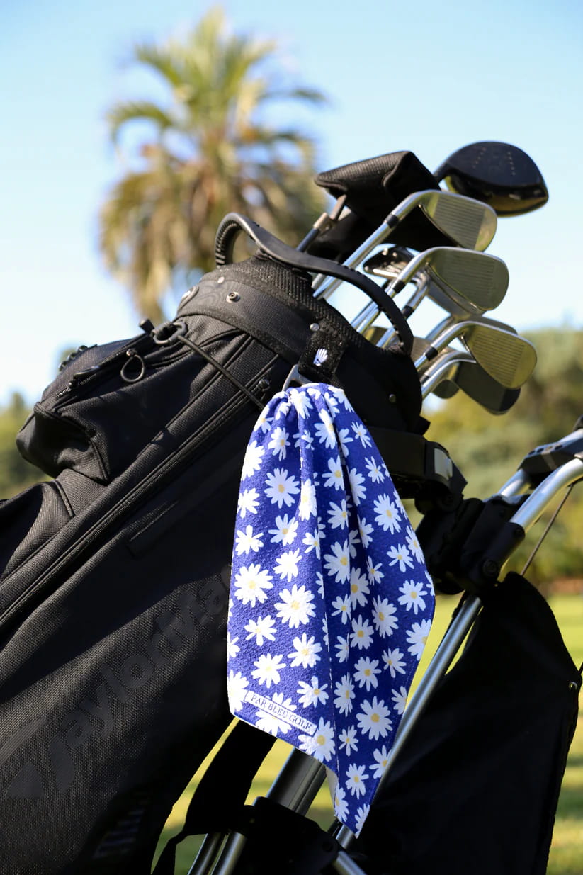 Stylish floral golf towel for women clipped to a golf bag with palm trees in the background