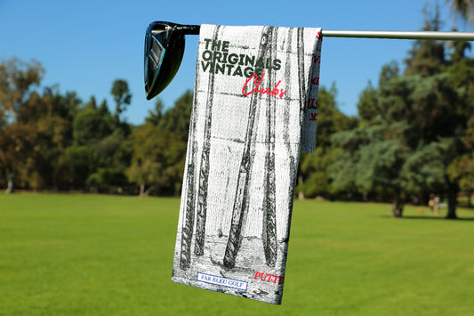 The Originals golf towel featuring vintage wooden club artwork hanging on a golf club over green fairway